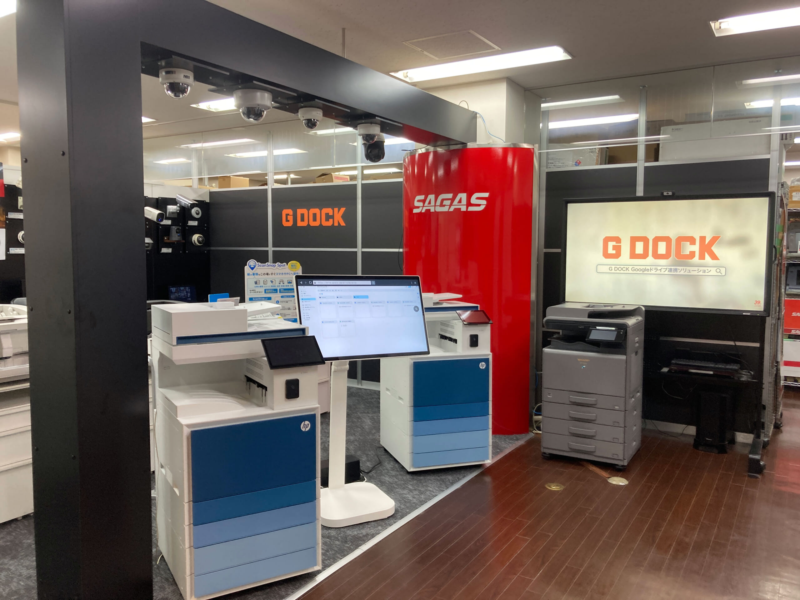 G DOCK 秋葉原ショールームの全景。HP複合機2台とモニター、奥にセキュリティカメラの展示壁