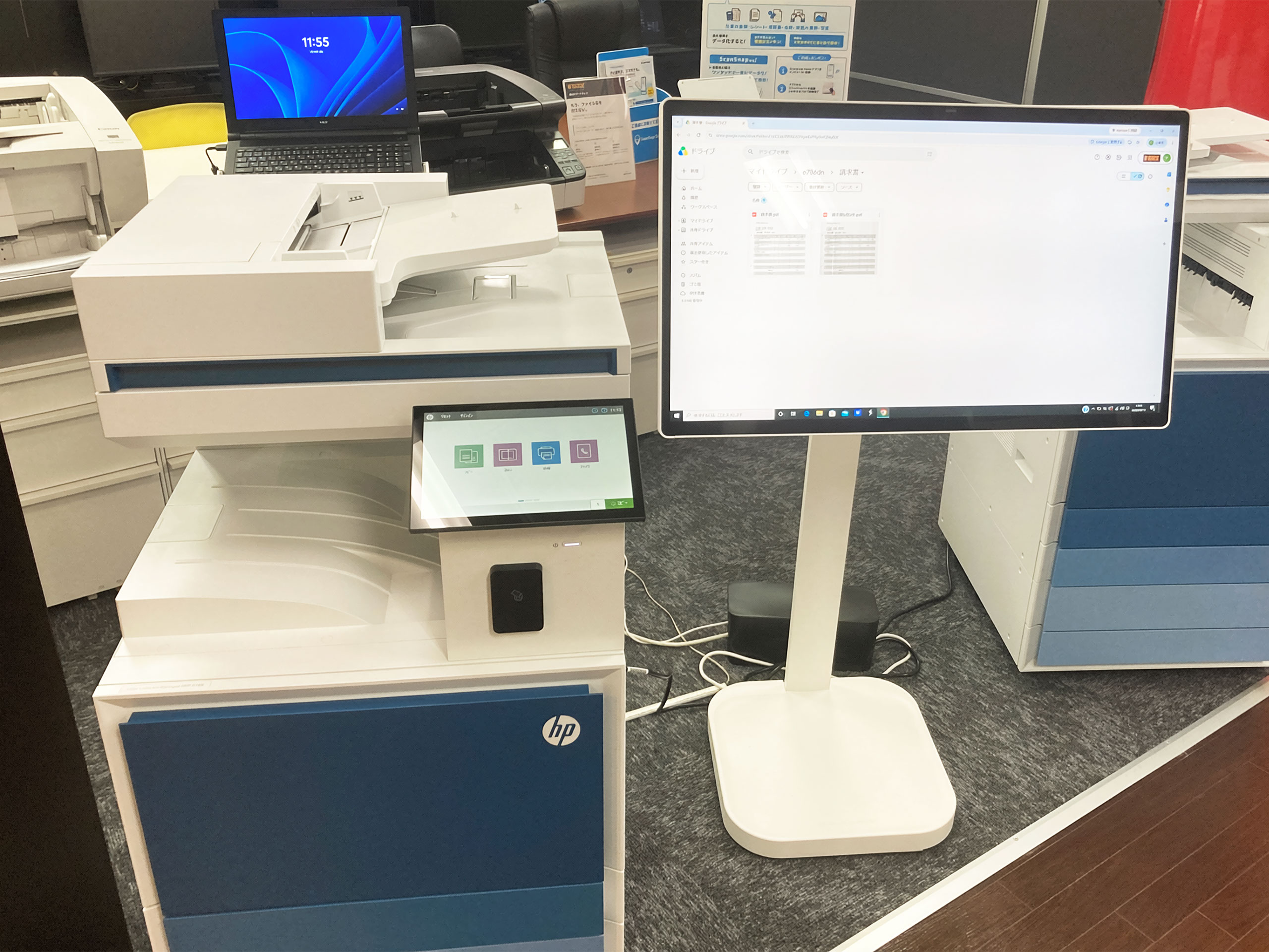 展示スペース。複合機の隣のモニターに、仕分けされた書類フォルダが表示されている